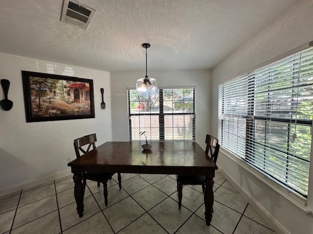 dining room with tile floors and a textured ceiling