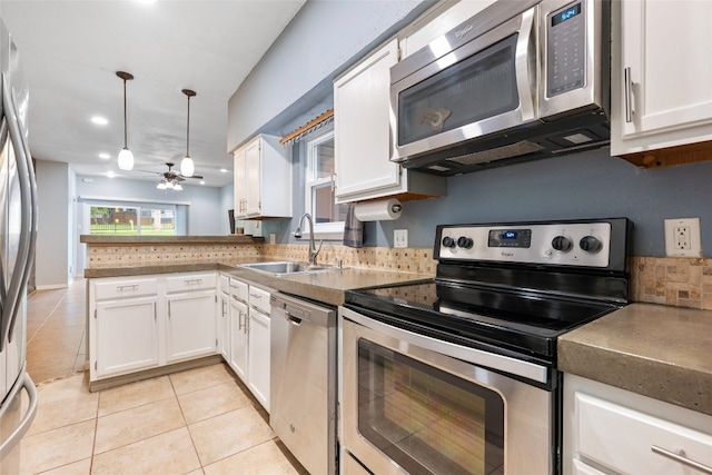 kitchen with pendant lighting, ceiling fan, appliances with stainless steel finishes, white cabinetry, and sink