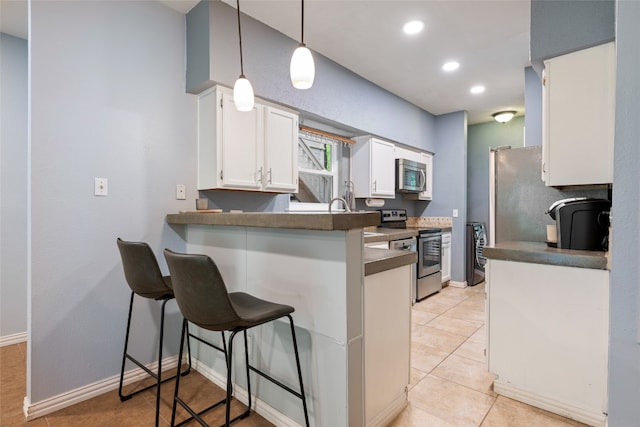 kitchen featuring pendant lighting, stainless steel appliances, a kitchen breakfast bar, kitchen peninsula, and white cabinets