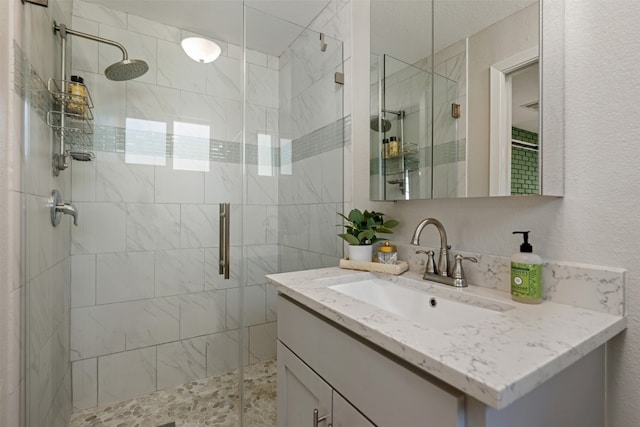 bathroom featuring a shower with shower door and large vanity