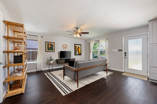 living room featuring ceiling fan and dark hardwood / wood-style flooring