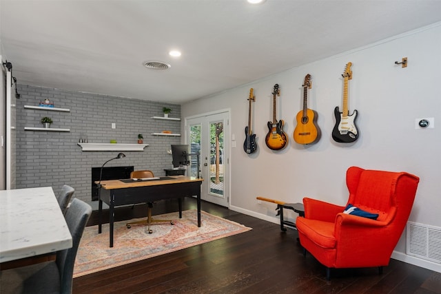 office space with a brick fireplace, brick wall, dark hardwood / wood-style floors, and french doors