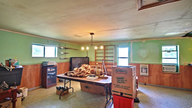 game room featuring wooden walls, heating unit, plenty of natural light, and cooling unit