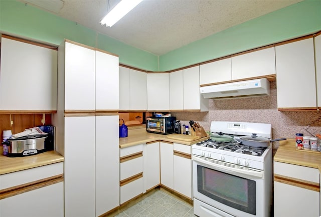 kitchen with white gas range and white cabinets