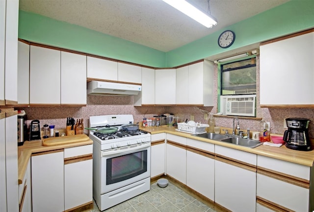 kitchen with a textured ceiling, white cabinetry, white gas stove, and sink