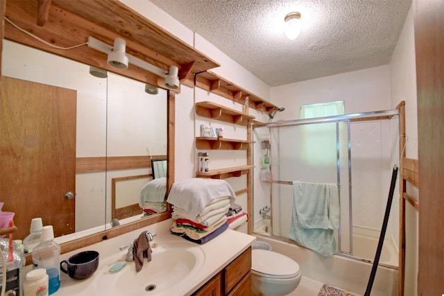 full bathroom with vanity, a textured ceiling, toilet, and bath / shower combo with glass door