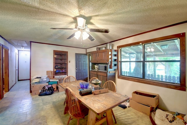 dining room with a textured ceiling, ceiling fan, and ornamental molding