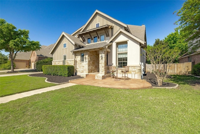 view of front of home with a patio area, a front yard, and a garage