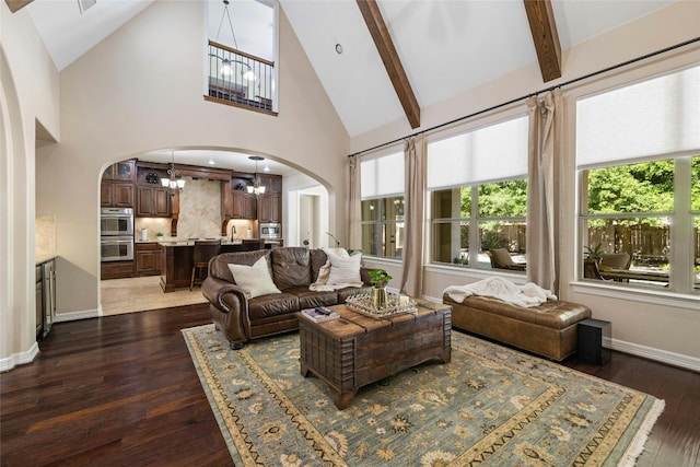 living room with an inviting chandelier, beam ceiling, high vaulted ceiling, and dark hardwood / wood-style floors