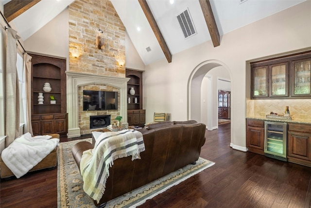 living room featuring high vaulted ceiling, beamed ceiling, wine cooler, a stone fireplace, and dark hardwood / wood-style flooring