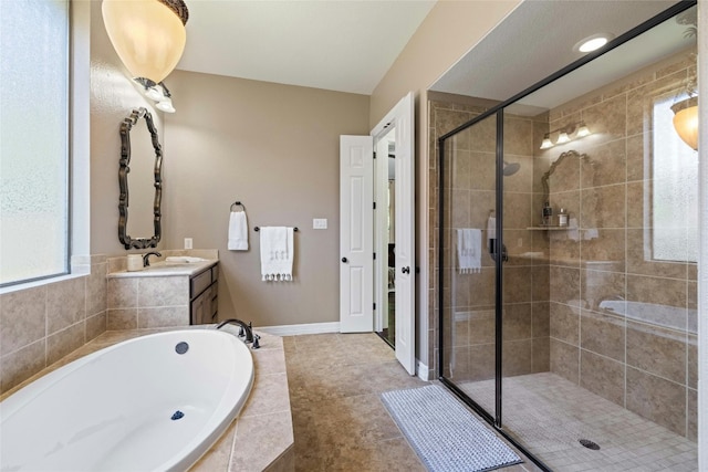 bathroom with separate shower and tub, tile floors, and vanity