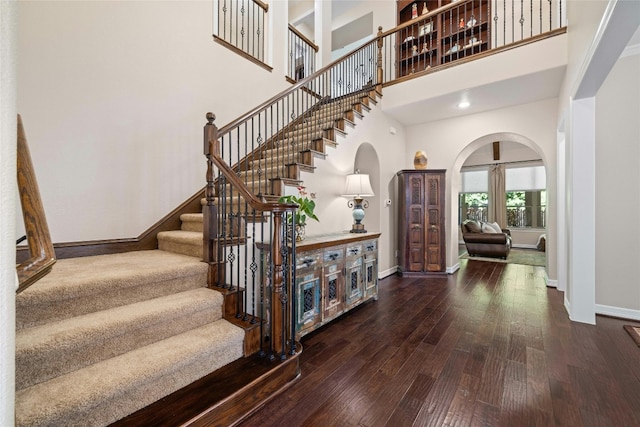 entrance foyer with dark wood-type flooring and a high ceiling