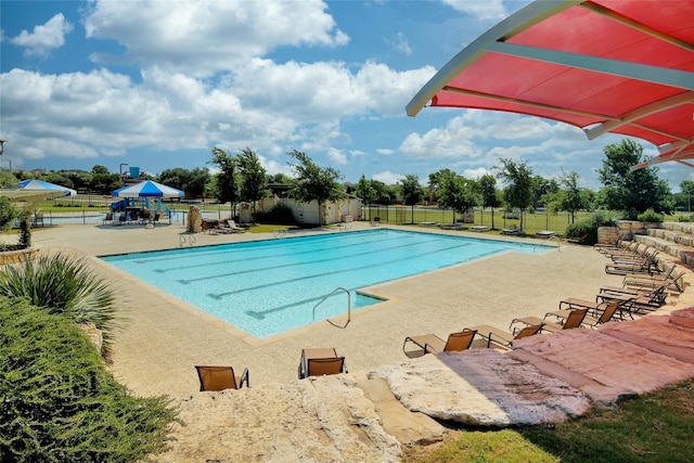 view of swimming pool featuring a playground