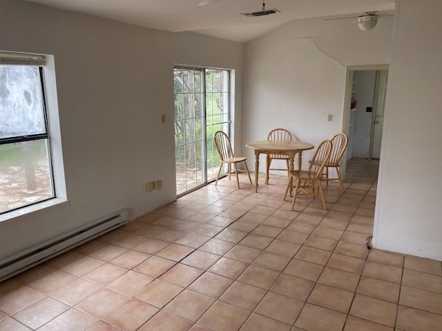 tiled dining area featuring ceiling fan, lofted ceiling, and a baseboard heating unit