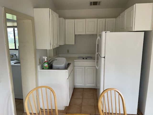 kitchen featuring washer / dryer, white cabinets, tile flooring, white appliances, and sink