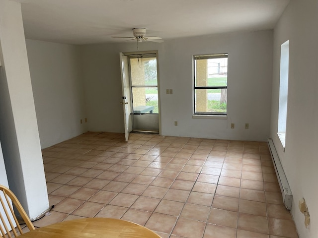 unfurnished room featuring ceiling fan, baseboard heating, and light tile floors