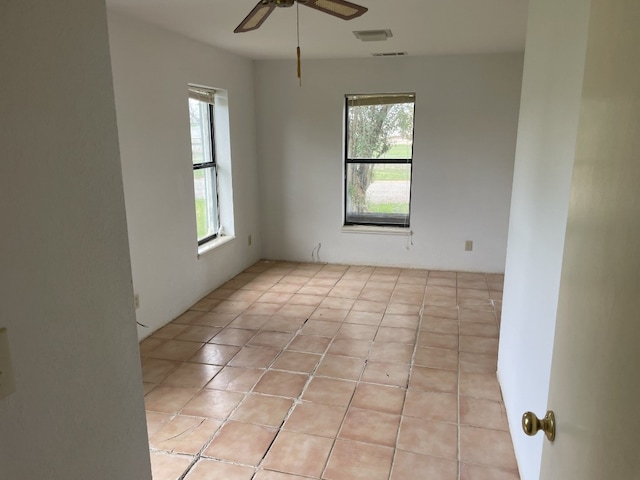 tiled spare room featuring ceiling fan