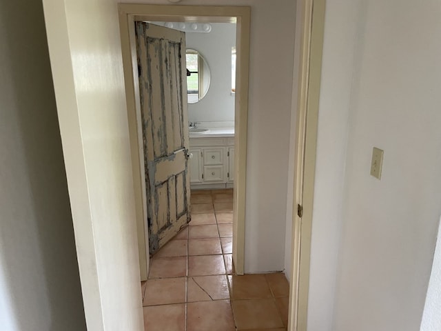 hallway featuring sink and light tile flooring