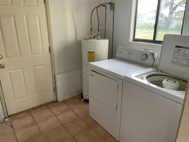 washroom featuring light tile floors, water heater, and washing machine and clothes dryer