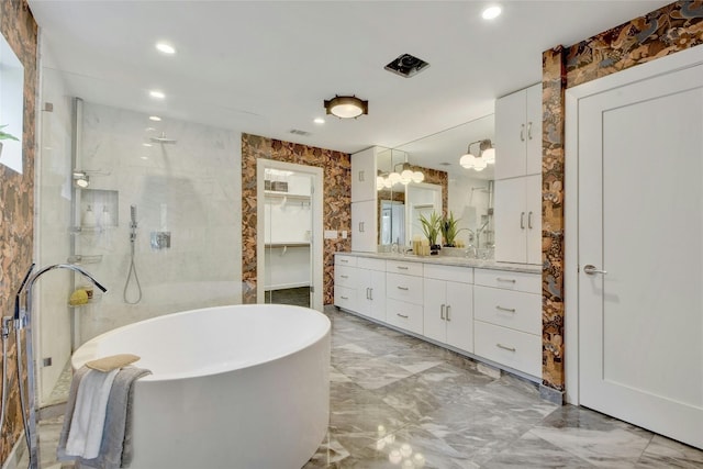 full bath featuring a stall shower, marble finish floor, a freestanding tub, and vanity