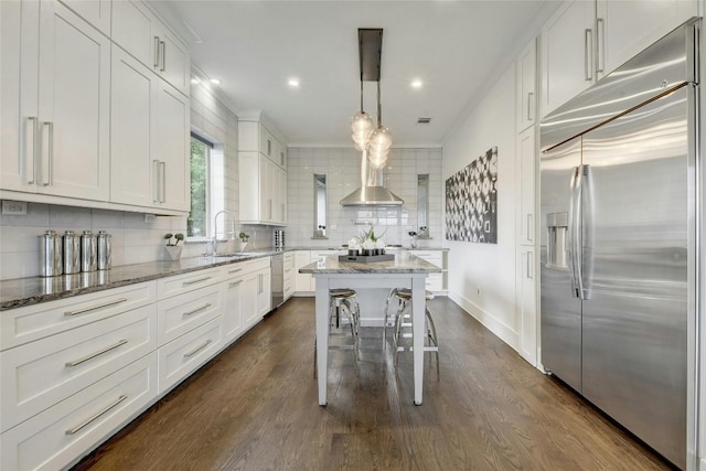 kitchen featuring dark wood-style floors, tasteful backsplash, appliances with stainless steel finishes, and a sink