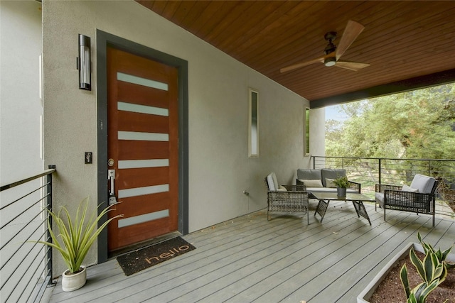 wooden deck with outdoor lounge area and ceiling fan