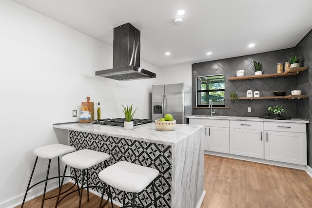 bar with white cabinetry, light hardwood / wood-style flooring, stainless steel appliances, tasteful backsplash, and island exhaust hood