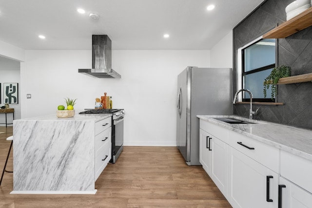 kitchen featuring light hardwood / wood-style floors, sink, stainless steel appliances, white cabinets, and wall chimney exhaust hood