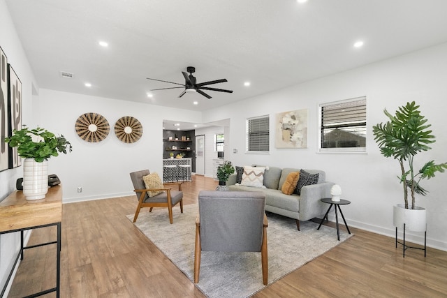 living room featuring light hardwood / wood-style flooring and ceiling fan