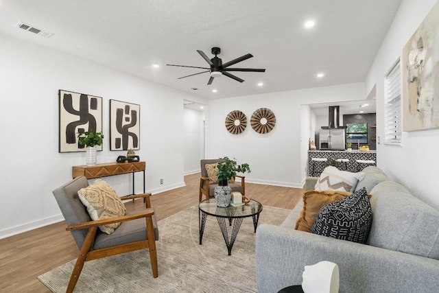 living room featuring ceiling fan and light hardwood / wood-style floors