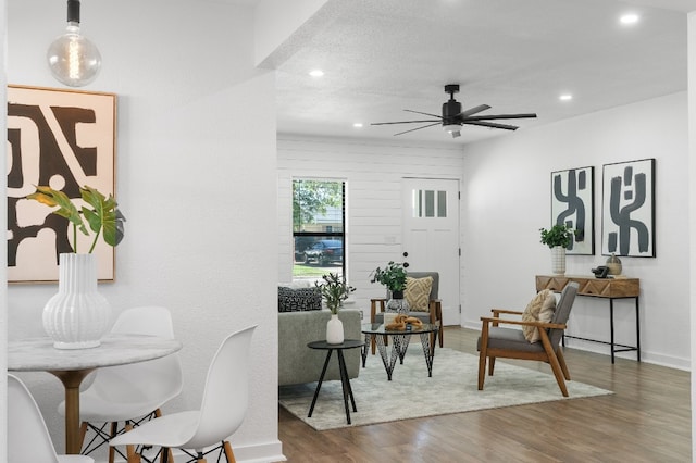 living area featuring a textured ceiling, wood-type flooring, and ceiling fan