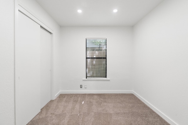 unfurnished room featuring light colored carpet