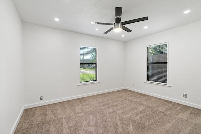 carpeted spare room featuring ceiling fan