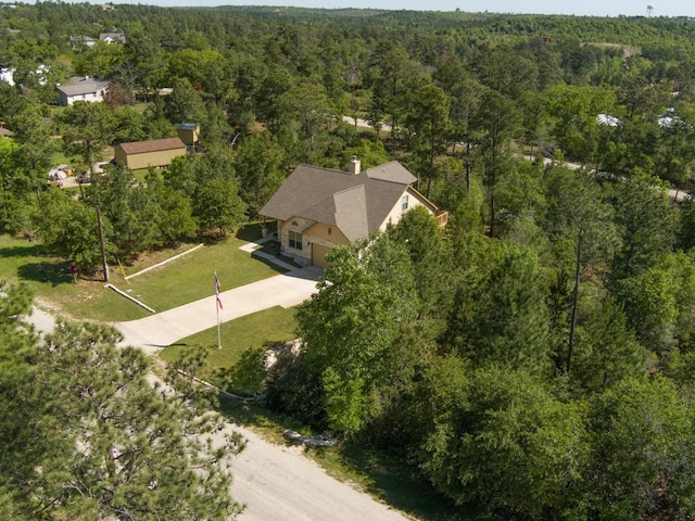 birds eye view of property with a view of trees