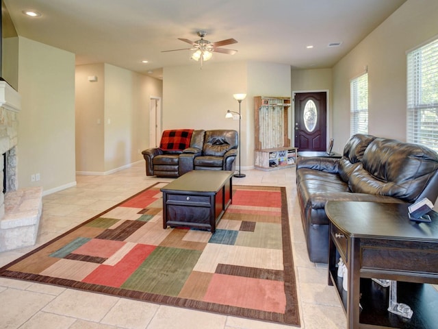 living room with ceiling fan and a fireplace