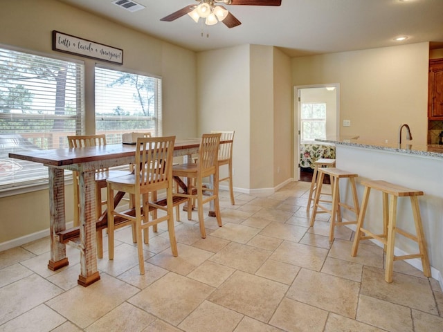 dining room with ceiling fan and sink