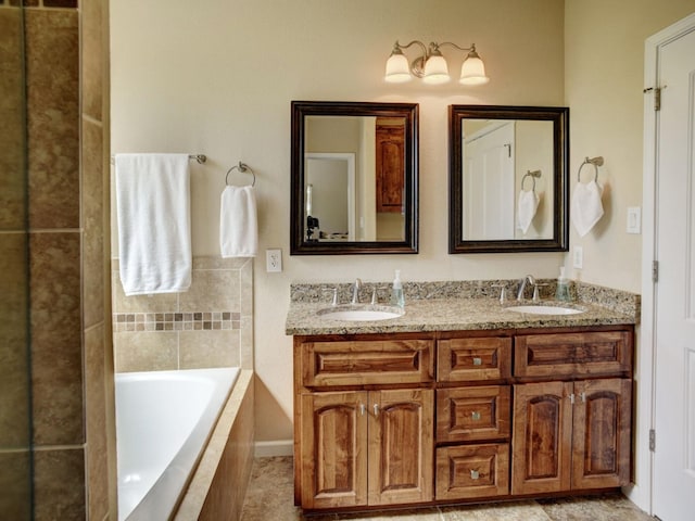 bathroom with double vanity, tiled bath, and a sink