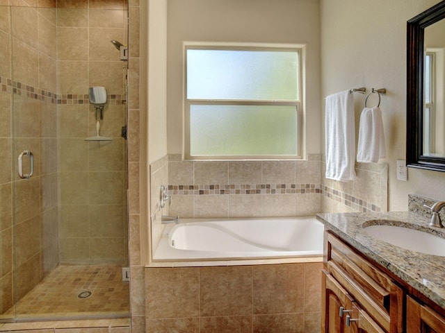 bathroom featuring vanity, shower with separate bathtub, and a wealth of natural light