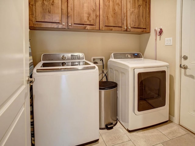 washroom featuring cabinets, independent washer and dryer, and light tile patterned flooring