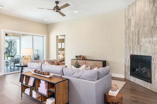 living room featuring dark hardwood / wood-style floors, ceiling fan, and a tile fireplace