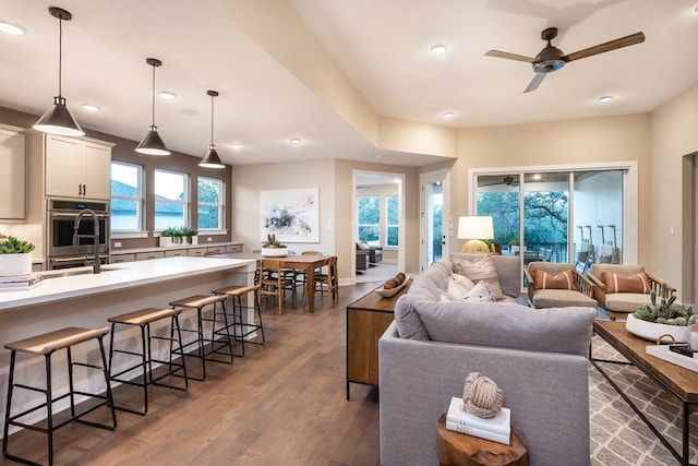 living room featuring ceiling fan and dark wood-type flooring