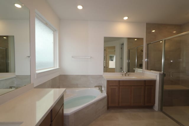 bathroom with tile patterned floors, vanity, a healthy amount of sunlight, and shower with separate bathtub