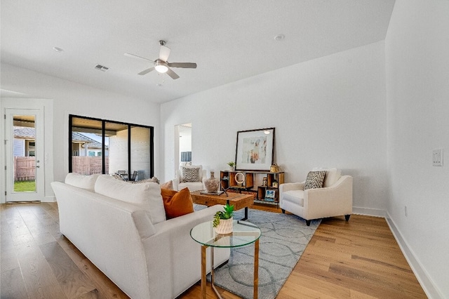 living room featuring hardwood / wood-style floors and ceiling fan