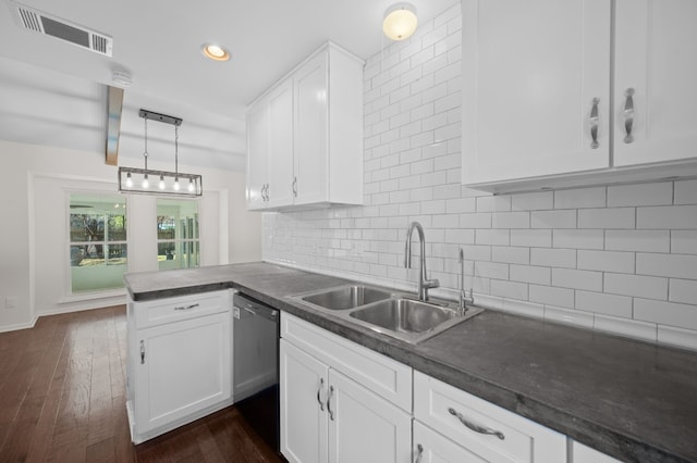 kitchen with kitchen peninsula, dishwasher, sink, and white cabinets