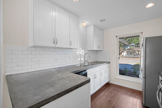 kitchen featuring sink, dark wood-type flooring, stainless steel fridge, decorative backsplash, and white cabinets