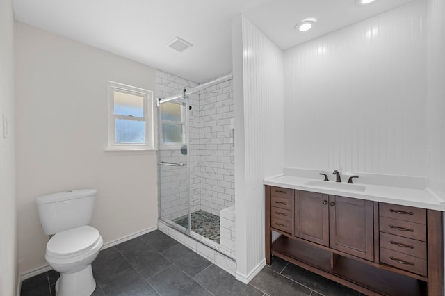 bathroom with tile patterned floors, vanity, a shower with shower door, and toilet