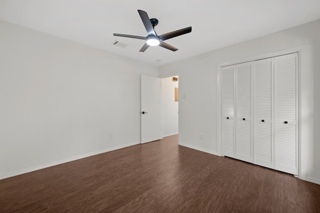 unfurnished bedroom with ceiling fan, a closet, and dark hardwood / wood-style floors