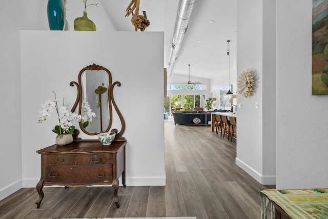 hall with high vaulted ceiling and hardwood / wood-style floors