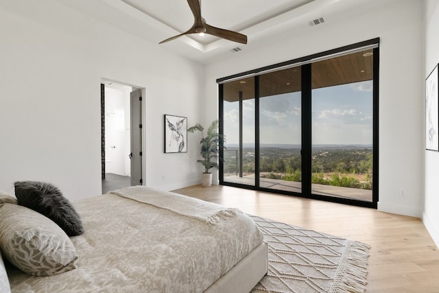 bedroom featuring light hardwood / wood-style floors, ceiling fan, and access to outside