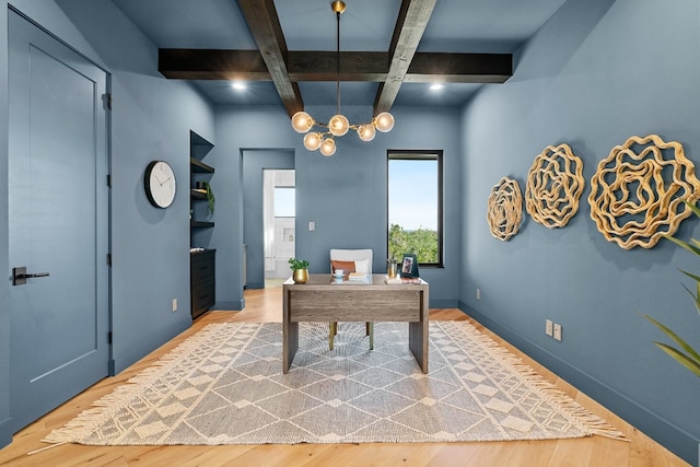 office space featuring an inviting chandelier, light hardwood / wood-style flooring, beam ceiling, and coffered ceiling